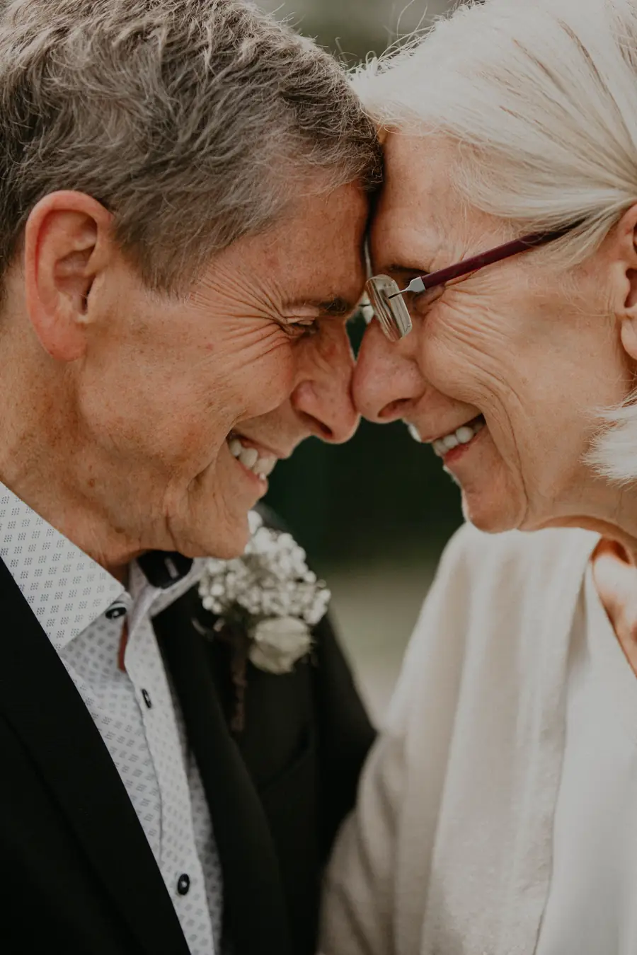 Una pareja mayor, frente con frente, sonriendo