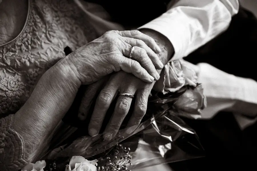 Las manos de una pareja mayor, con el anillo de bodas